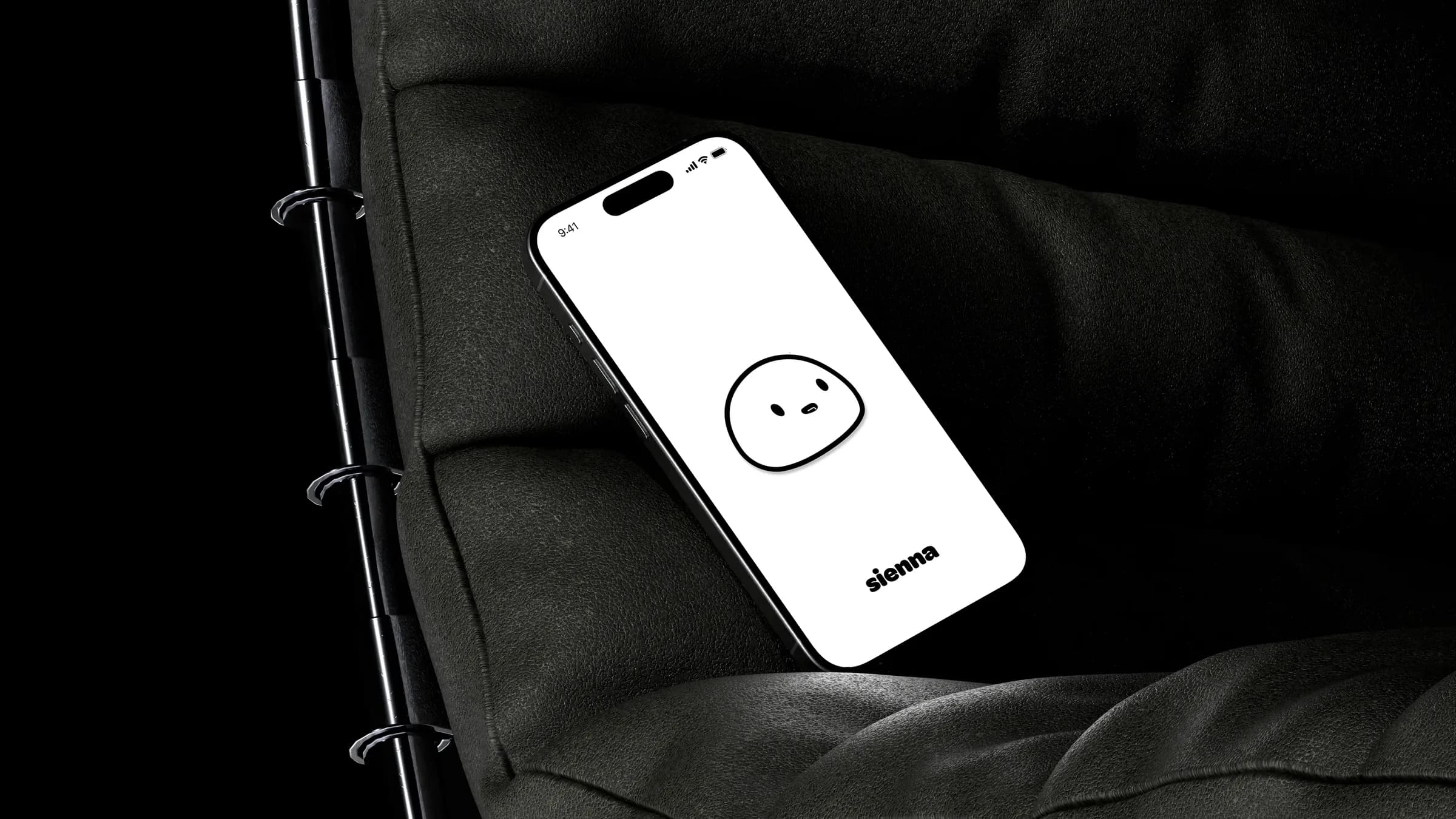 The sienna splash screen on an iPhone resting on a dark armchair
